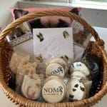 A gift basket with NOMV cookies and a thank you card